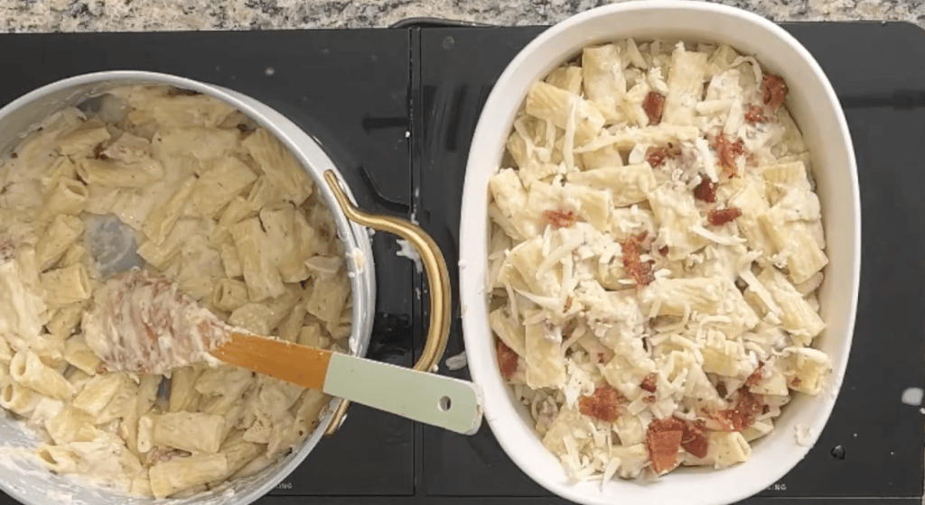 A pot of creamy pasta stirred with a wooden spoon, next to a baking dish filled with layered pasta topped with cheese and diced tomatoes.